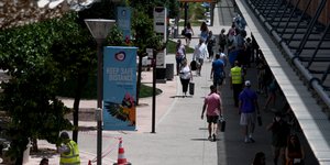 Κόσμος περπατάει έξω από εμπορικό κέντρο