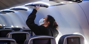 Γυναίκα με μάσκα στο εσωτερικό αεροπλάνου