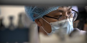 Ερευνητής με μάσκα και γυαλιά σε έρευνα για τον κορωνοϊό