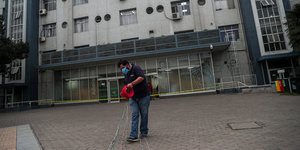 Εργάτης απλώνει καλώδια φορώντας μάσκα για κορωνοϊό