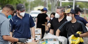 Εθελοντές μοιράζουν τρόφιμα στην Φλόριντα φορώντας μάσκα για τον κορωνοϊό