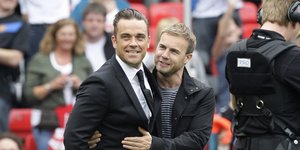 Ρόμπι Γουίλιαμς και Γκάρι Μπάρλοου αγκαλιά σε γήπεδο ποδοσφαίρου