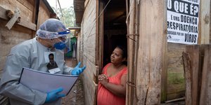 Γιατρός σε παράγκες μιλά με γυναίκα για τον κορωνοϊό