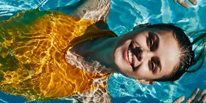 Γυναίκα με κίτρινο μαγιό στην πισίνα 