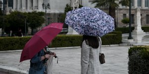 Γυναίκες με ομπρέλες στο κέντρο της Αθήνας