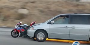 Οδηγός ΙΧ συνεχίζει την πορεία του σε δρόμο της Καλιφόρνια, με μια μοτοσυκλέτα στον μπροστινό προφυλακτήρα