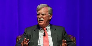 Ο Τζον Μπόλτον καθιστός σε πολυθρόνα