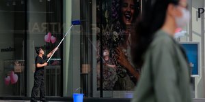 Υπάλληλος στη Κίνα καθαρίζει τζάμια καταστήματος