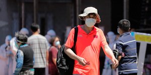 Κινέζος περπατά φορώντας μάσκα για τον κορωνοϊό