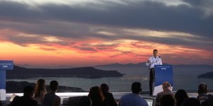 Ο Κυριάκος Μητσοτάκης με φόντο το ηλιοβασίλεμα της Σαντορίνης