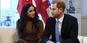 Η Μέγκαν Μαρκλ με καφέ φόρεμα και ο πρίγκιπας Χάρι με γαλάζια γραβάτα