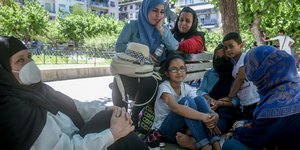 μετανάστριες με παιδιά σε παγκάκι 