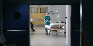 Νοσηλευτής μεταφέρει κρεβάτι