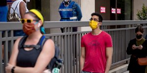 Κόσμος σε ουρά φορώντας μάσκα για τον κορωνοϊό