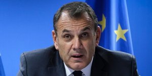 Ο Νίκος Παναγιωτόπουλος με φόντο την ελληνική και την ευρωπαϊκή σημαία