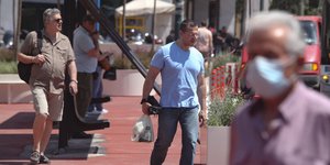 πολιτες περπατουν στην κοκκινη λωριδα