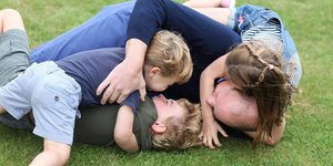 Ο πρίγκιπας Γουίλιαμ παίζει στο γρασίδι με τα τρία του παιδιά