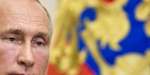 Ο Ρώσος Πρόεδρος Βλαντιμίρ Πούτιν με φόντο της σημαία της ρωσικής ομοσπονδίας