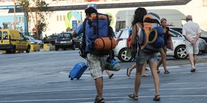 Τουρίστες ετοιμάζονται να επιβιβαστούν σε πλοίο στον Πειραιά