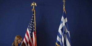 Υπάλληλος φροντίζει τις σημαίες των ΗΠΑ και της Ελλάδας