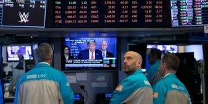 Χρηματιστές στη Νέα Υόρκη κοιτάζουν τον Τραμπ στην τηλεόραση