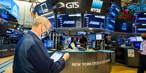 Χρηματιστής κοιτάζει το τάμπλετ του σε αίθουσα στο χρηματιστήριο της Νέας Υόρκης