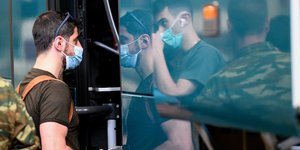 Ανδρας με μάσκα επιβιβάζεται σε πούλμαν