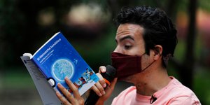 Ανδρας με μάσκα για τον κορωνοϊό, διαβάζει απόσπασμα από βιβλίο στο Μεξικό