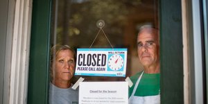 Ανδρόγυνο πίσω από πόρτα κλειστού καταστήματος