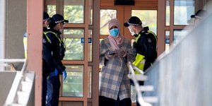 Αστυνομικοί μιλούν με γυναίκα στην Μελβούρνη, φορώντας μάσκες για τον κορωνοϊό