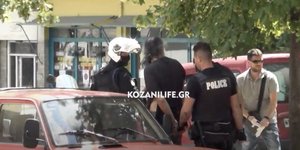 Αστυνομικοί με τον δράστη της επίθεσης με τσεκούρι στη ΔΟΥ στην Κοζάνη