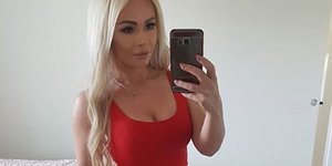 Η ξανθιά Φινλανδή μητέρα ποζάρει με κόκκινο φόρεμα γεμάτη αυτοπεποίθηση