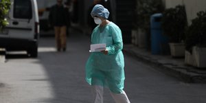 γιατρός με μάσκα και στολή περπατά