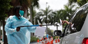 Υπάλληλος δίνει από απόσταση φυλλάδιο σε οδηγό