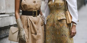 Δυο γυναίκες με φορέματα κρατούν τσάντα με αλυσίδα