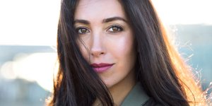 Γυναίκα με μαύρα μακριά μαλλιά και ροζ κραγιόν 