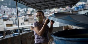 Γυναίκα σε ταράτσα στην Βραζιλία με μάσκα για τον κορωνοϊό