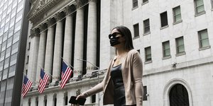 Γυναίκα με μάσκα για τον κορωνοϊό έξω από το χρηματιστήριο της Νέας Υόρκηςς