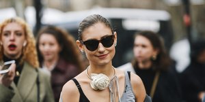 Γυναίκα φορά γυαλιά ηλίου και κολιέ 