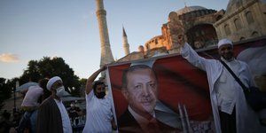 Μουσουλμάνοι πανηγυρίζουν με μια εικόνα του Ερντογάν μπροστά στην Αγιά Σοφιά