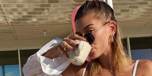 Χάλι Μπίμπερ πίνει καφέ και φοράει λευκό πουκάμισο