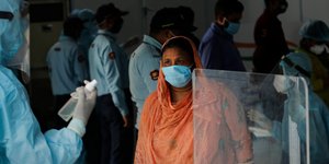 Ινδή με παραδοσιακή φορεσιά και μάσκα υποβάλλεται σε έλεγχο για τον κορωνοϊό