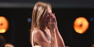 Τζένιφερ Άνιστον με λευκό φόρεμα συγκινημένη