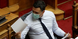 O Βασίλης Κικίλιας επιδεικνύει χαρτιά φορώντας μάσκα στην Βουλή