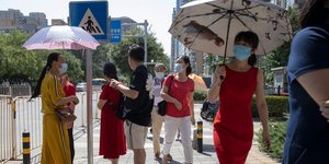 Κινέζες περπατούν φορώντας μάσκες για τον κορωνοϊό