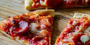 Κομμάτια πίτσας σε ξύλινο τραπέζι