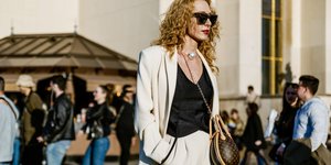 Ξανθιά γυναίκα με λευκό κοστούμι και μαύρα γυαλιά