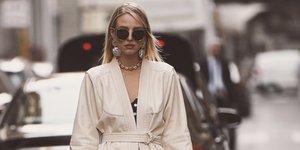 Ξανθιά γυναίκα στο δρόμο κρατά τσάντα, φορά γυαλιά 