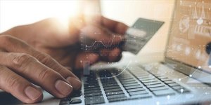 Ανδρας με κάρτα μπροστά από λάπτοπ