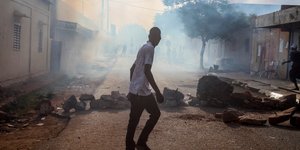 Νεαρός στο Μάλι σε δρόμο με καπνούς και πέτρες